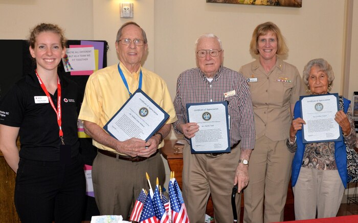 American Red Cross volunteers William Mehard (2nd to left) a retired Navy undersea warfare officer; Charles Vath (center), a retired Navy dentist; and Caroline Cramer (far right), a retired insurance claims officer, pose with Certificates of Appreciation they received from Naval Health Clinic Charleston Commanding Officer Capt. Elizabeth Maley (2nd to right) during NHCC's Volunteer Appreciation Awards Ceremony April 20, 2017, at NHCC, located on the Joint Base Charleston - Weapons Station. All three volunteers were NHCC's nominees for the 2016 American Red Cross Palmetto SC Region Volunteer Award and the Joint Base Charleston Volunteer Excellence Award. Mehard, a resident of Hanahan, has volunteered more than 4,748 hours at NHCC, helping NHCC Pharmacy staff dispense approximately 534,600 prescriptions over the past 25 years. Vath, a resident of Mount Pleasant, has volunteered more than 3,314 hours at NHCC, helping dispense approximately 372,800 prescriptions in the last 15 years. Cramer, a resident of North Charleston, has volunteered more than 3,172 hours at NHCC, helping dispense approximately 356,850 prescriptions during the past 11 years. Both Mehard and Vath are veterans of the Korean and Vietnam wars. Also present in the photo, Carly Fountain (far left), Volunteer Services Specialist, American Red Cross Palmetto SC Region. 