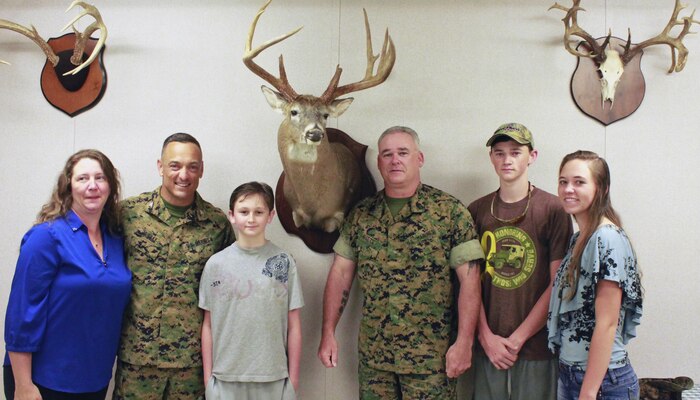 Master Gunnery Sgt. Steven Butts Sr.,(fourth from left) is joined by his family when he was awarded with an award for the largest kill of the hunting season by Col. Joseph Murray (second from left), commander, Marine Corps Instillations- National Capital Region, MCBQ at the Game Check Station located off Telegraph Rd just outside Marine Corps Base Quantico.