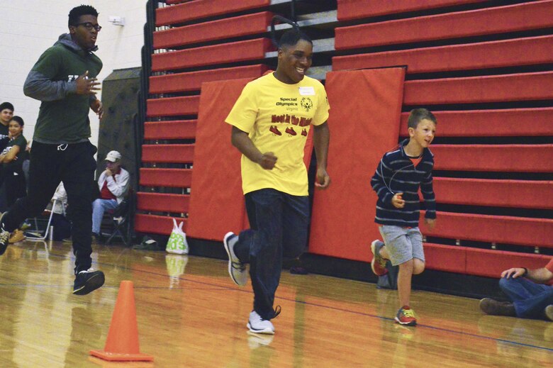 During the Exceptional Family Member Program Fifth Annual Special Olympics Fun Field Day Meet athletes participated in an array of Olympics style sporting events to include the 50 meter dash in which two Olympians have taken the lead in front of their volunteer buddy.