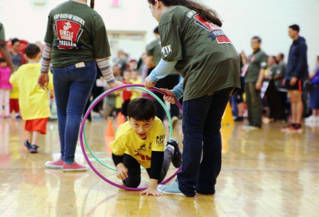 During the Exceptional Family Member Program Fifth Annual Special Olympics athletes participated in an array of Olympics style sporting events to include an obstacle course in which the Olympians weaved through cones, hopscotched, crawled through hoola hoops and limboed under rope.