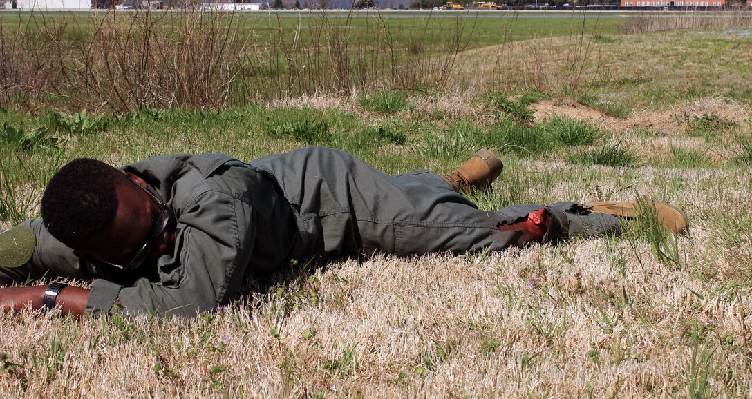 Suffering what appears to be a simulated broken leg this Marine cries out to the first responders for help. The first responders tied a yellow ribbon around his wrist thus signifying low risk.