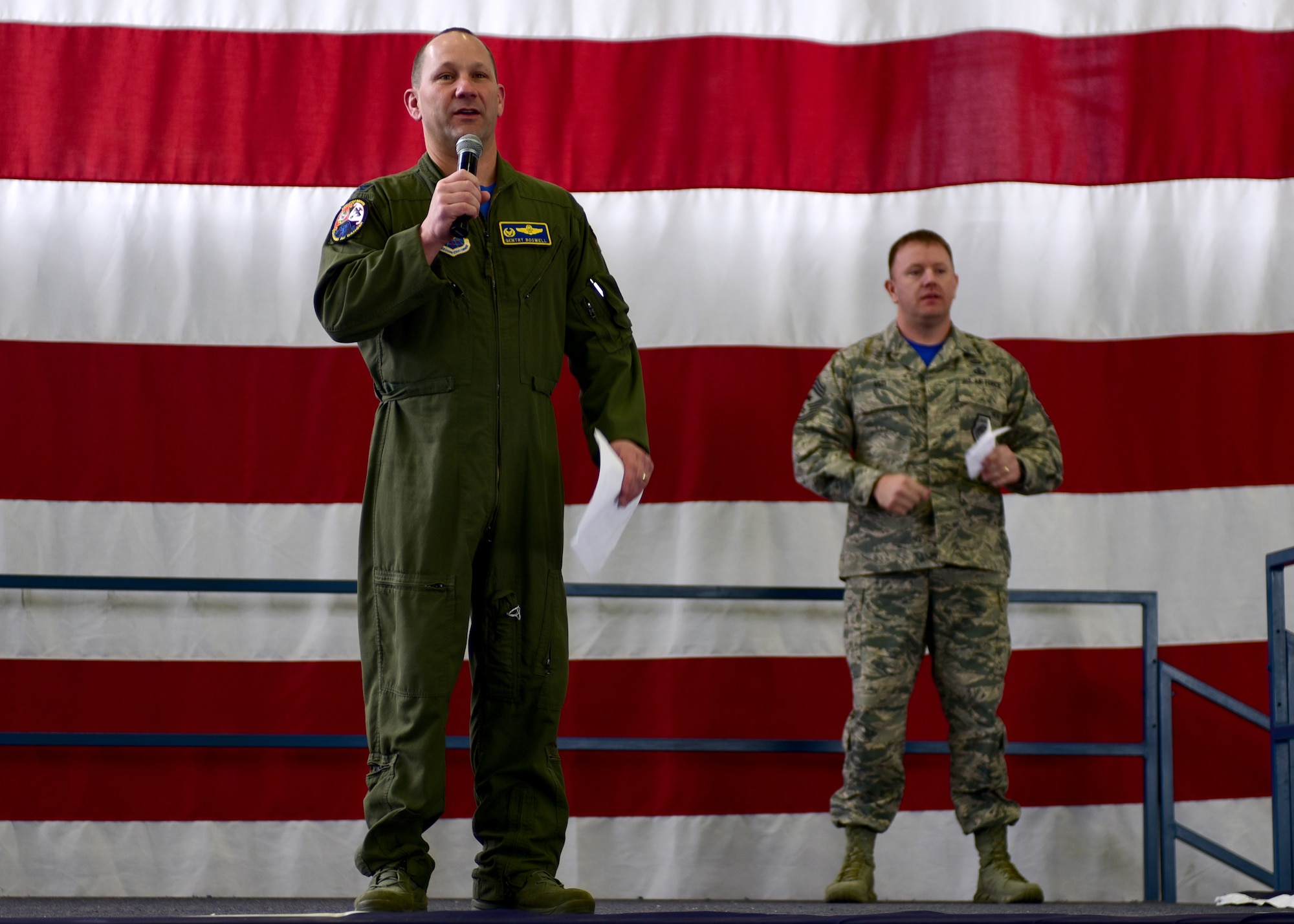 Col. Gentry Boswell, the commander of the 28th Bomb Wing (left), and Chief Master Sgt. Adam Vizi, the command chief of the 28th Bomb Wing, speak to Airmen during a semi-annual Wingman Day inside the Pride Hangar at Ellsworth Air Force Base, S.D., April 28, 2017. After a brief message from base leadership, nearly 2,300 Airmen participated in activities that developed them physically and socially. (U.S. Air Force photo by Airman 1st Class Randahl J. Jenson)