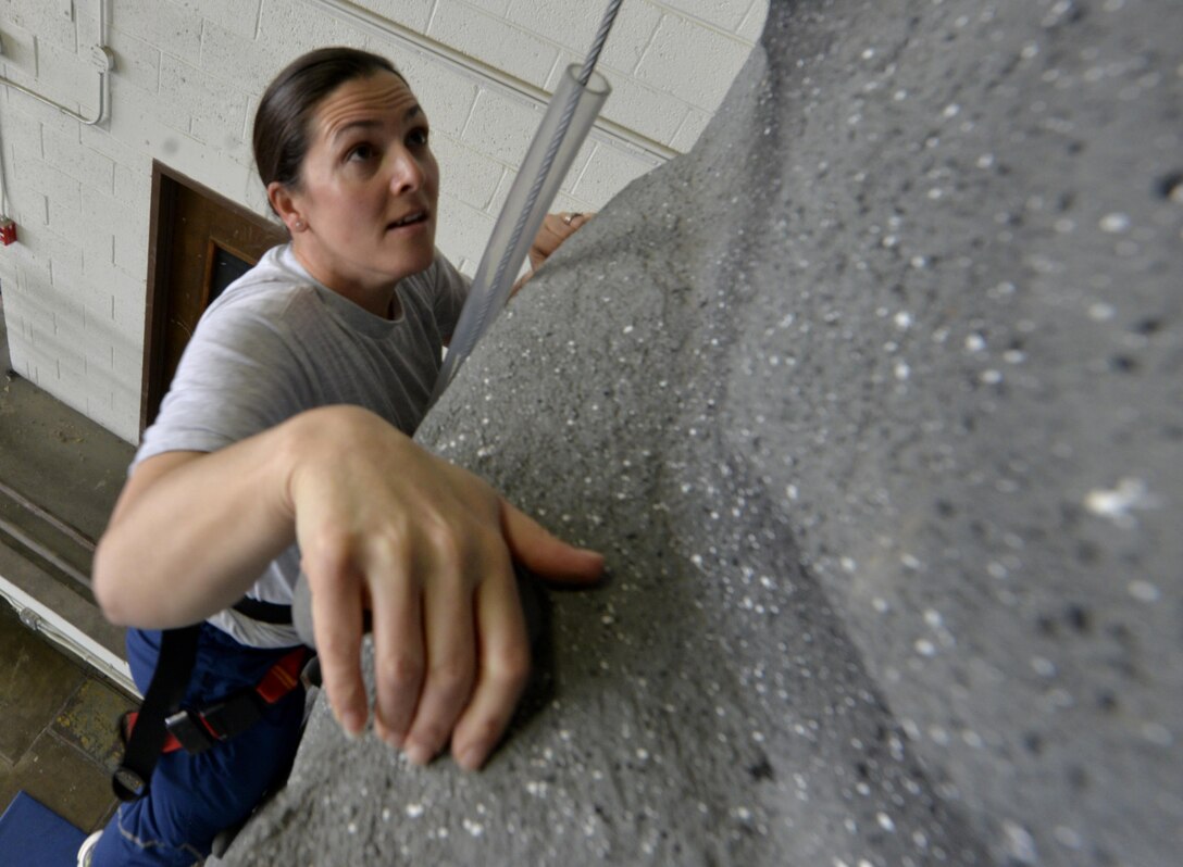 An Airman climbs the rock wall during a Wingman Day inside the Pride Hangar at Ellsworth Air Force Base, S.D., April 28, 2017. Nearly 2,300 Airmen participated in physical and social activities as part of the semi-annual event. (U.S. Air Force photo by Staff Sgt. Sarah Denewellis) 