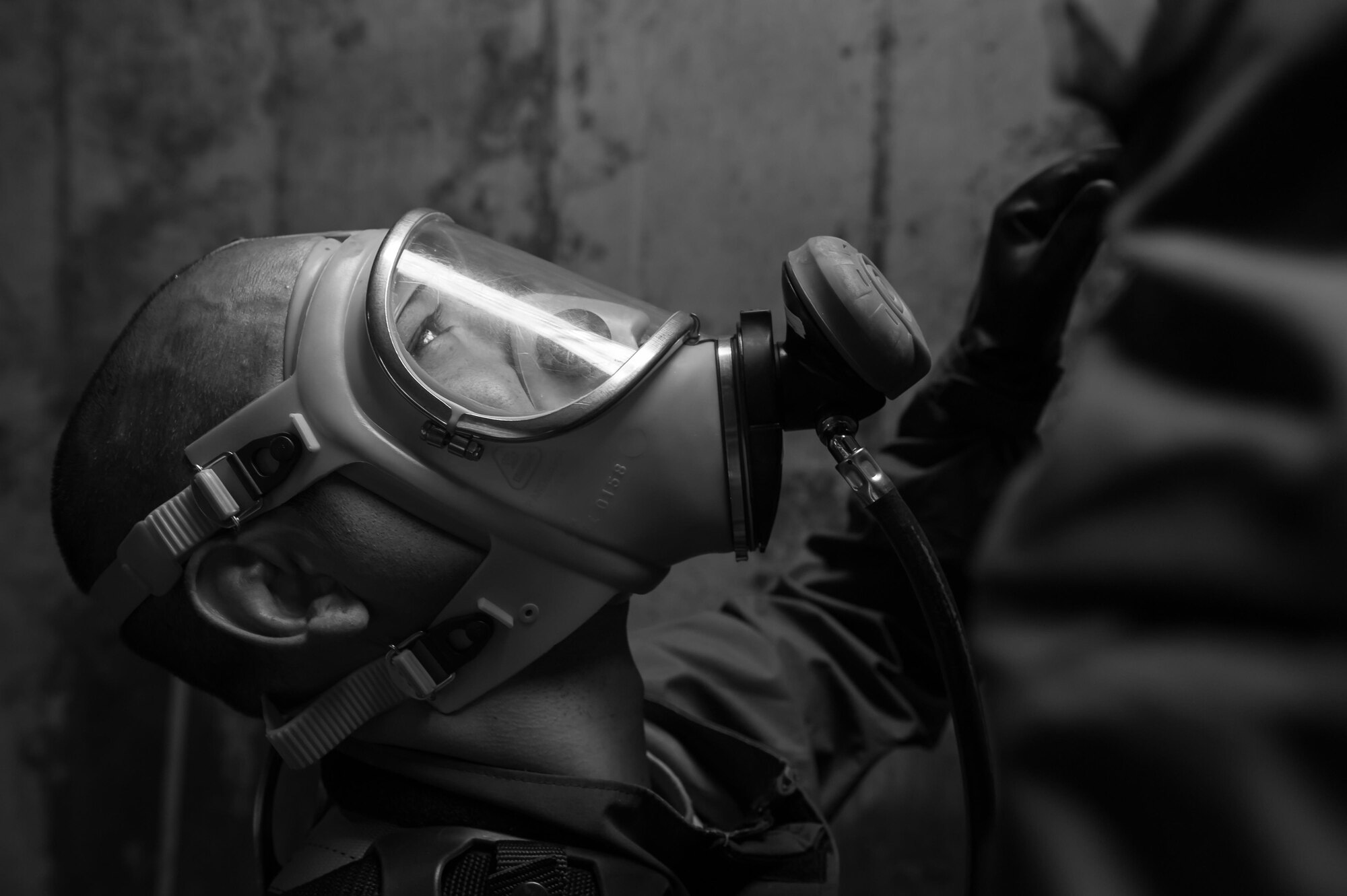 Staff Sgt. Sixto Trevino, 9th Civil Engineer Squadron water and fuels maintenance, waits in the underground tank for the safety cable to be lowered down to him before making the climb back to the surface at Beale Air Force Base, California, April 27, 2017. Safety cables are attached to the wearer's harness in the event that they cannot make the climb on their own due to safety issues. (U.S. Air Force photo by Airman 1st Class Justin Parsons/Released)