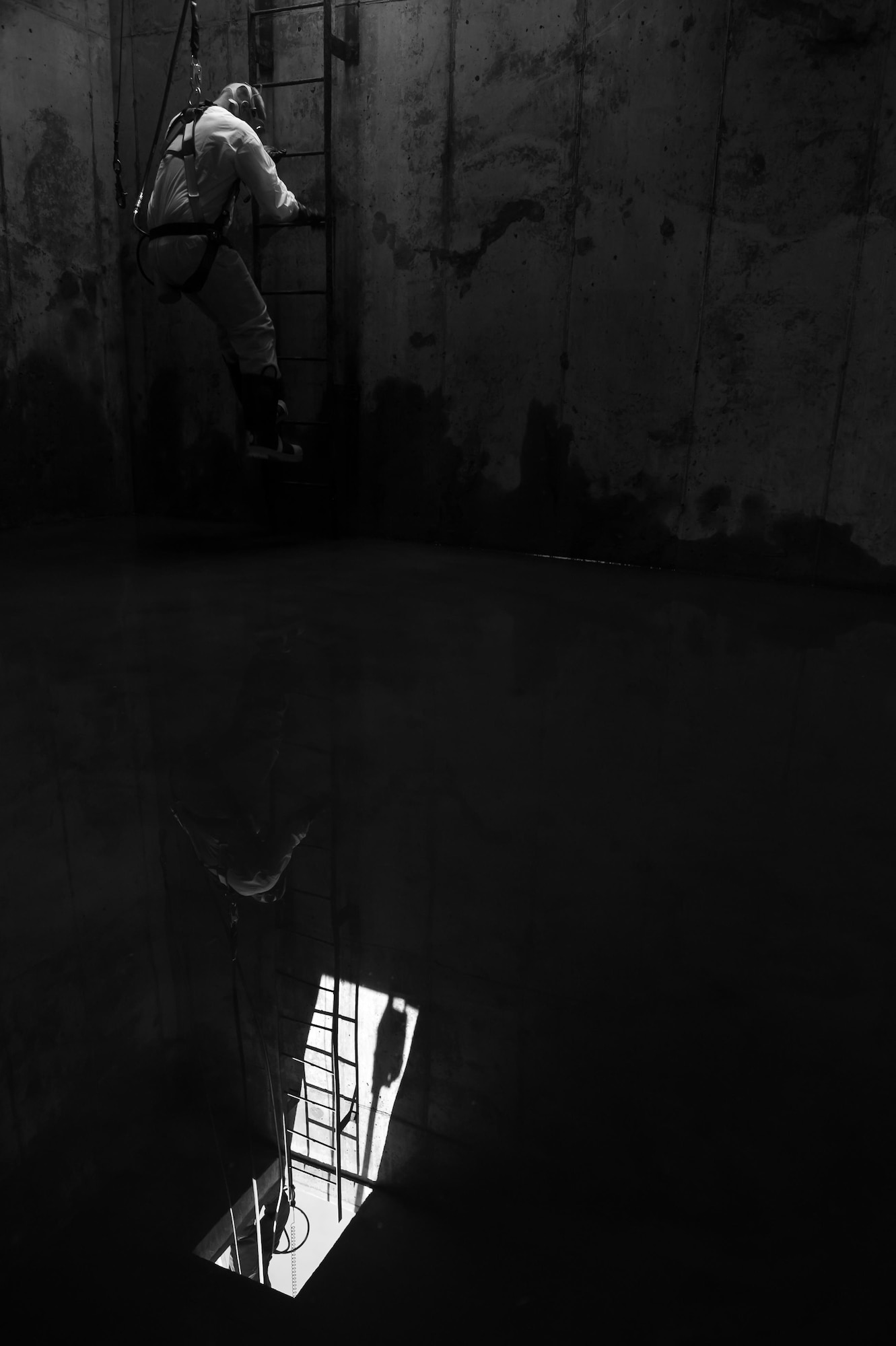 Staff Sgt. Joshua Manske, 9th Civil Engineer Squadron water and fuels systems maintenance, steps into the underground confined space to clean a tank and perform maintenance on a storage unit at Beale Air Force Base, California, April 27, 2017. Members of 9th CES perform regular routine inspections and general maintenance on various types of storage units on the installation. (U.S. Air Force photo by Airman 1st Class Justin Parsons/Released)