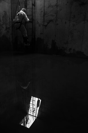 Staff Sgt. Joshua Manske, 9th Civil Engineer Squadron water and fuels systems maintenance, steps into the underground confined space to clean a tank and perform maintenance on a storage unit at Beale Air Force Base, California, April 27, 2017. Members of 9th CES perform regular routine inspections and general maintenance on various types of storage units on the installation. (U.S. Air Force photo by Airman 1st Class Justin Parsons/Released)
