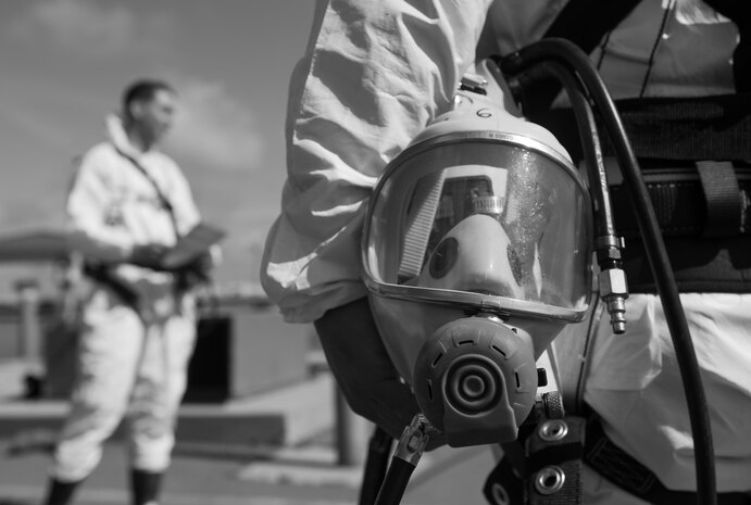 Troy Bodey, 9th Civil Engineer Squadron water and fuels systems maintenance, holds onto his gas mask while listening to a safety brief given by the confined space entry supervisor at Beale Air Force Base, California, April 27, 2017. Supervisors of a confined space entry team are responsible for assigning roles and ensuring that safety protocols are followed. (U.S. Air Force photo by Airman 1st Class Justin Parsons/Released)