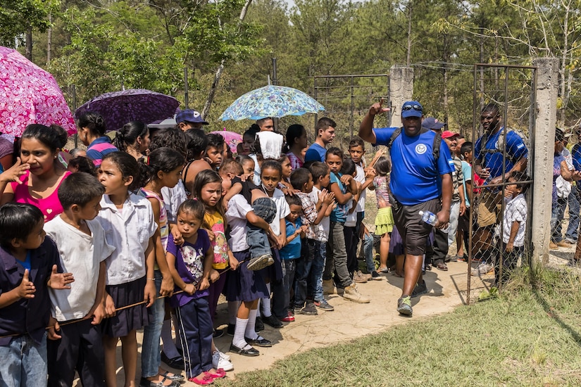 Villagers of San Jerónimo, Comayagua, Honduras wait for more than 190 members of Joint Task Force-Bravo to hiked approximately 3.6 miles round-trip to the village, Apr. 29, 2017. Members carried more than 5025 lbs of food and supplies, 24 soccer balls and 3 piñatas to the people of San Jerónimo. Chapel hikes have been occurring since 2003, with the JTF-Bravo Chapel sponsoring an average of six every year. The hikes are designed to provide a practical way for JTF-Bravo members to engage and partner with local communities to provide support to surrounding villages in need of food and supplies. (U.S. Air National Guard photo by Master Sgt. Scott Thompson/released)