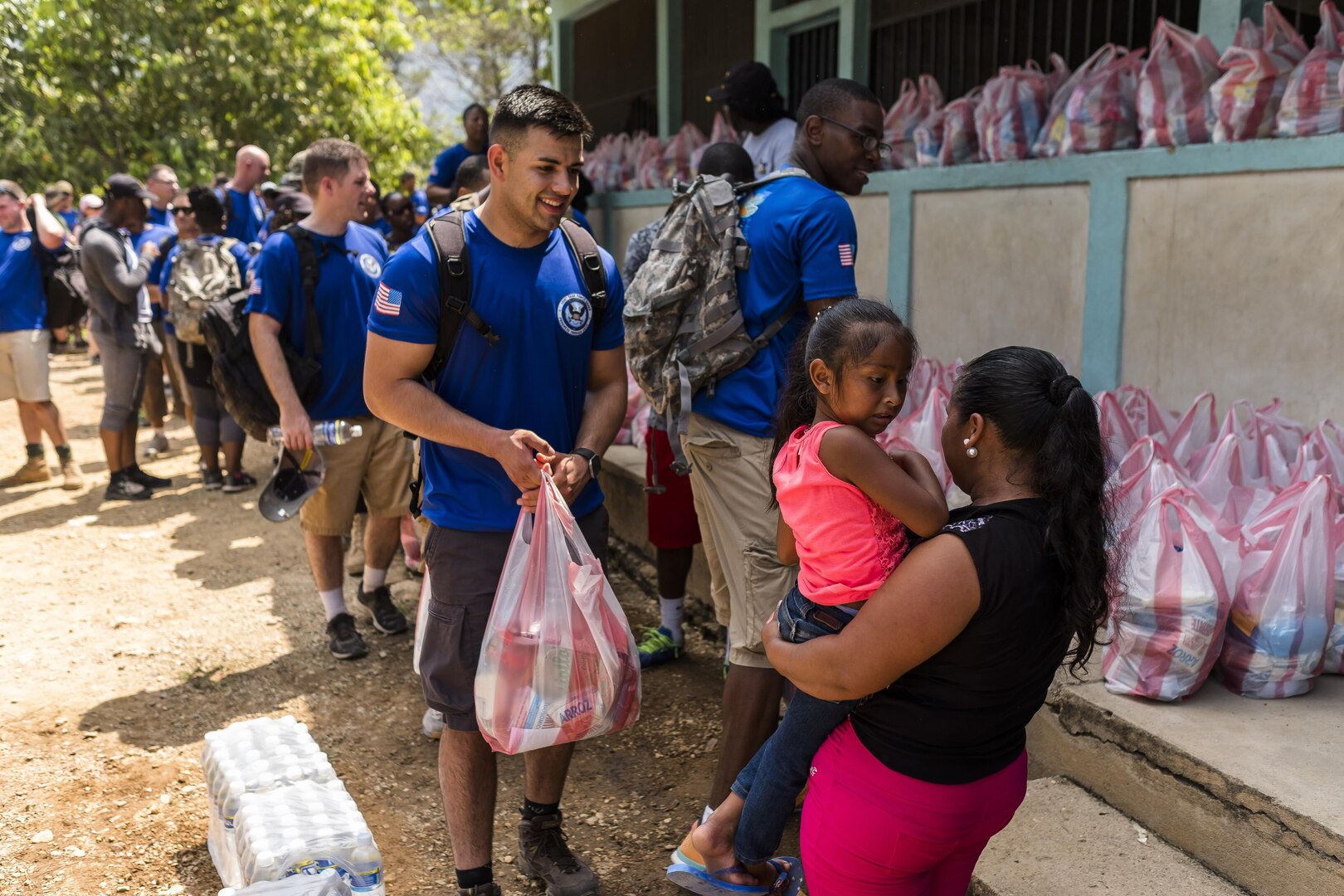 Villagers of San Jerónimo, Comayagua, Honduras receive bags of food from more than 190 members of Joint Task Force-Bravo to hiked approximately 3.6 miles round-trip to the village, Apr. 29, 2017. Members carried more than 5025 lbs of food and supplies, 24 soccer balls and 3 piñatas to the people of San Jerónimo. Chapel hikes have been occurring since 2003, with the JTF-Bravo Chapel sponsoring an average of six every year. The hikes are designed to provide a practical way for JTF-Bravo members to engage and partner with local communities to provide support to surrounding villages in need of food and supplies. (U.S. Air National Guard photo by Master Sgt. Scott Thompson/released)