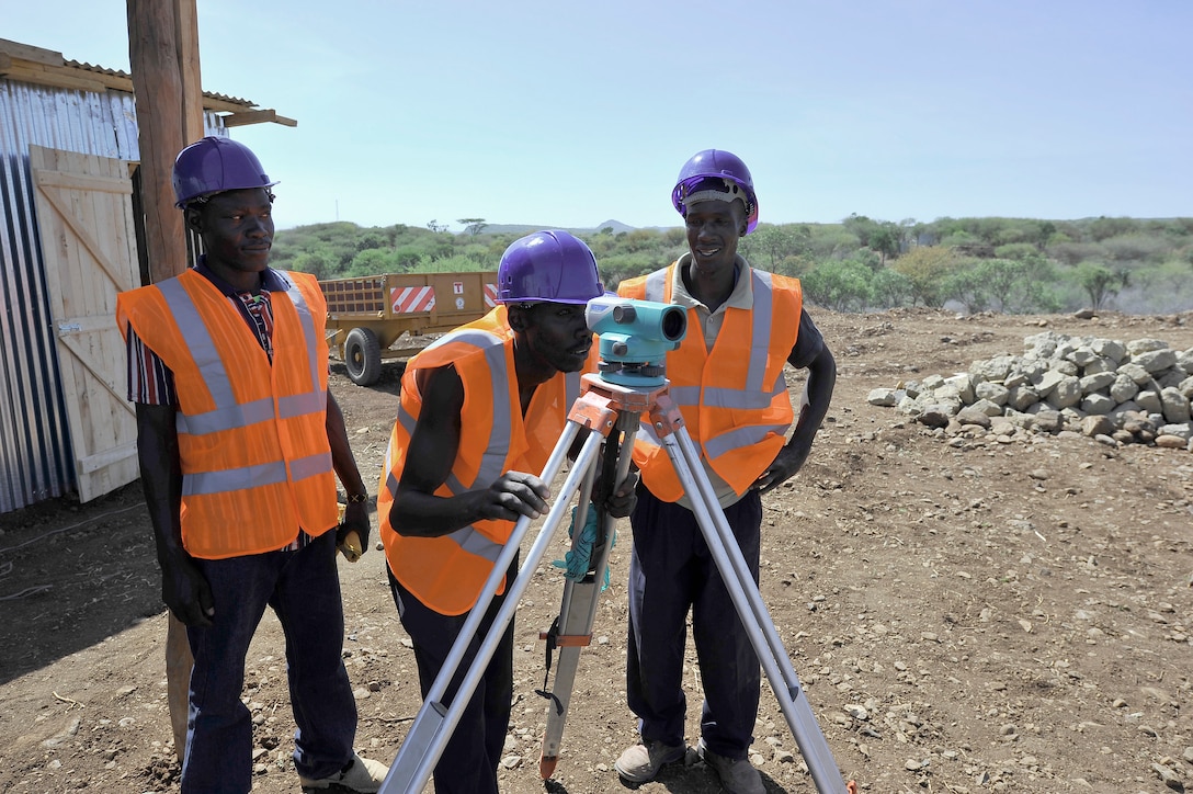 In 2014, water workers survey a biomass site in Kenya as part of the USAID Power Africa initiative.  