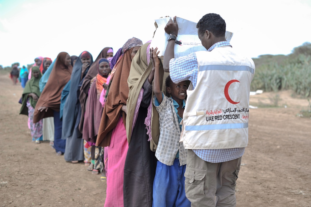 A young boy receives a box of food from a UAE Red Crescent employee at a distribution center in Somalia in August 2013. The UAE Red Crescent gave out food to more than 5,000 internally displaced persons aided in part by AMISOM forces.