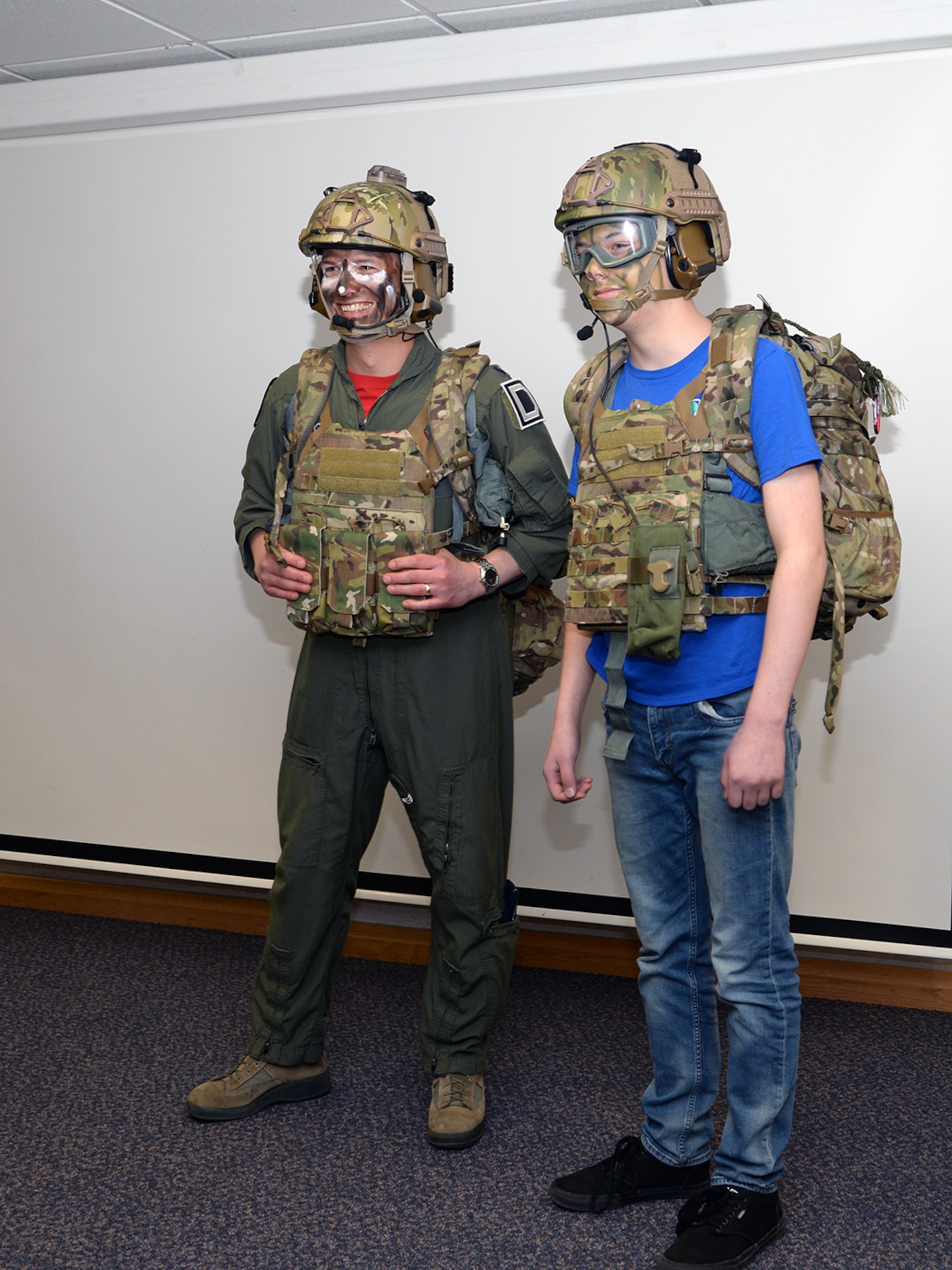U.S Air Force Lt Col. Jason Barnes, left, 351st Air Refueling Squadron commander, and his son Ian, 13, pose for a photo after being dressed in survival, evasion, resistance and escape gear during a demonstration at the “Bring Your Child to Work Day” for Month of the Military Child April 28, 2017, at the 100th Operations Group on RAF Mildenhall, England. In addition to hanging out with their parents at work, children had the opportunity to see a KC-135 Stratotanker close up, listen to some kid-friendly briefings, participate in physical training and take part in SERE training. (U.S. Air Force photo by Karen Abeyasekere)