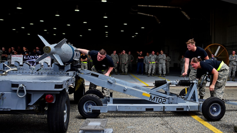 U.S. Air Force Airmen assigned to the 27th Aircraft Maintenance Unit weapons crew, load munitions onto a rack during the 1st Maintenance Group Load Crew of the Quarter competition at Joint Base Langley-Eustis, Va., April 28, 2017. Both load crews and members in attendance donned black T-shirts to pay their respects to Senior Airmen Sara Toy and Austin Terrell, and Staff Sgt. Alexandria Morrow during the event. 