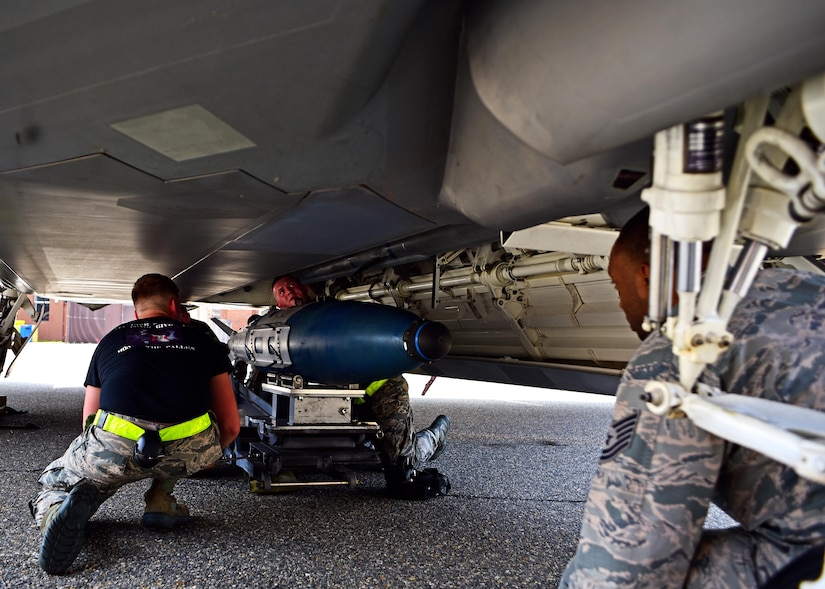 U.S. Air Force Airmen assigned to the 27th Aircraft Maintenance Unit weapons crew, load munitions onto an F-22 Raptor during the 1st Maintenance Group Load Crew of the Quarter competition at Joint Base Langley-Eustis, Va., April 28, 2017. The two three-person teams were hand-picked by their squadrons and judged on their job knowledge, dress and appearance, tool box inspection and professionalism. 