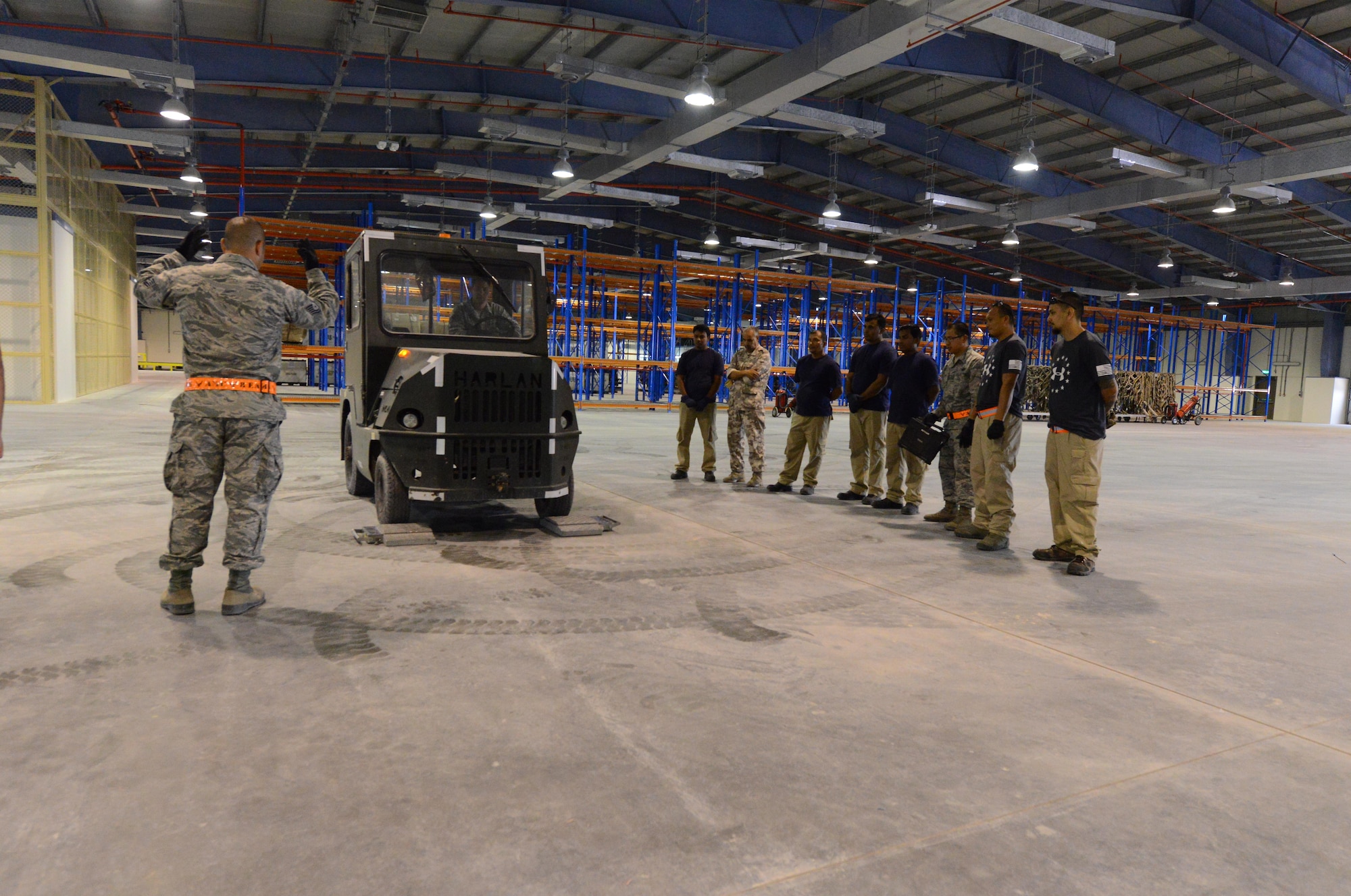 U.S. Air Force and Qatari air force personnel gather around a vehicle inside a newly constructed facility located at Al Udeid Air Base, Qatar, April 26, 2017. The personnel are taking part in the first of many opportunities to train on how to properly collect information necessary to determine the total weight and center of gravity for equipment to be loaded for transportation on aircraft.