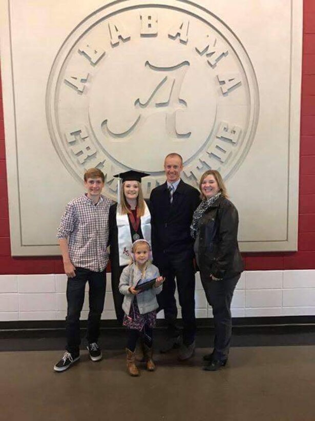 U.S. Air Force Lt. Col. Kenneth Walker (second from right), 7th Comptroller Squadron commander, his wife, Liz (far right), and his family smile for the camera after his daughter’s college graduation at the University of Alabama in Tuscaloosa, Ala. Liz received the Hap Arnold grant for two years under the Air Force Assistance Fund while attending college as a young spouse to then, Airman 1st Class Kenneth Walker. (Courtesy photo)