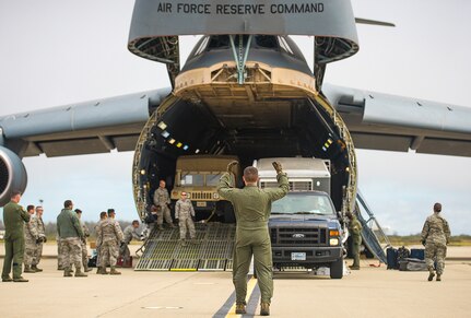 Airmen with the 68th Airlift Squadron unload vehicles from a C-5M Super Galaxy aircraft during exercise Patriot Hook April 26, 2017 at Vandenberg Air Force Base, California. Patriot Hook is an annual joint-service exercise coordinated by the Air Force Reserve, designed to integrate the military and first responders of federal, state and local agencies by providing training to mobilize quickly and deploying in military aircraft in the event of a regional emergency or natural disaster. (U.S. Air Force photo by Benjamin Faske)