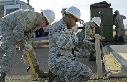Senior Airman Ranses Rojas and Staff Sgt. Jared Bull,  433rd Contingency Response Element radio frequency transmissions, use 4,000 pound jacks to level the Hard Side Expandable Light Air Mobile Shelter during exercise Patriot Hook April 27, 2017 at Vandenberg Air Force Base, California. Patriot Hook is an annual joint-service exercise coordinated by the Air Force Reserve, designed to integrate the military and first responders of federal, state and local agencies by providing training to mobilize quickly and deploy in military aircraft in the event of a regional emergency or natural disaster.  (U.S. Air Force photo by Benjamin Faske)