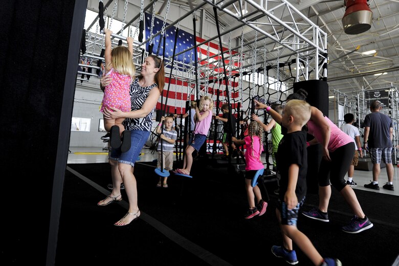 Team Hurlburt and families participate in the Alpha Warrior Battle Rig competition at the Commando Hangar on Hurlburt Field, Fla., April 29. Alpha Warrior is an obstacle competition similar to that of the television competition show American Ninja Warrior. The competition challenged grip-strength, agility and core strength. The Alpha Warrior competition travels throughout the U.S. to offer service members the opportunity to maneuver the battle rig’s obstacles. (U.S Air Force photo by Airman 1st Class Dennis Spain)