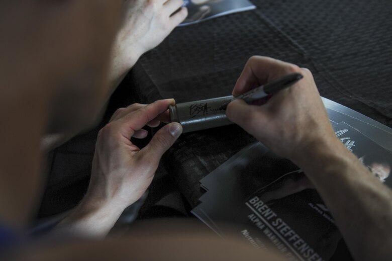 Brent Steffensen, the managing partner of Alpha Warrior, autographs a 22mm round from an AC-130U Spooky gunship at Hurlburt Field, Fla., April 29, 2017. After competiting the Alpha Warrior competition, participants were invited to get autographs from the Alpha Warrior professionals. (U.S. Air Force photo by Airman 1st Class Dennis Spain)