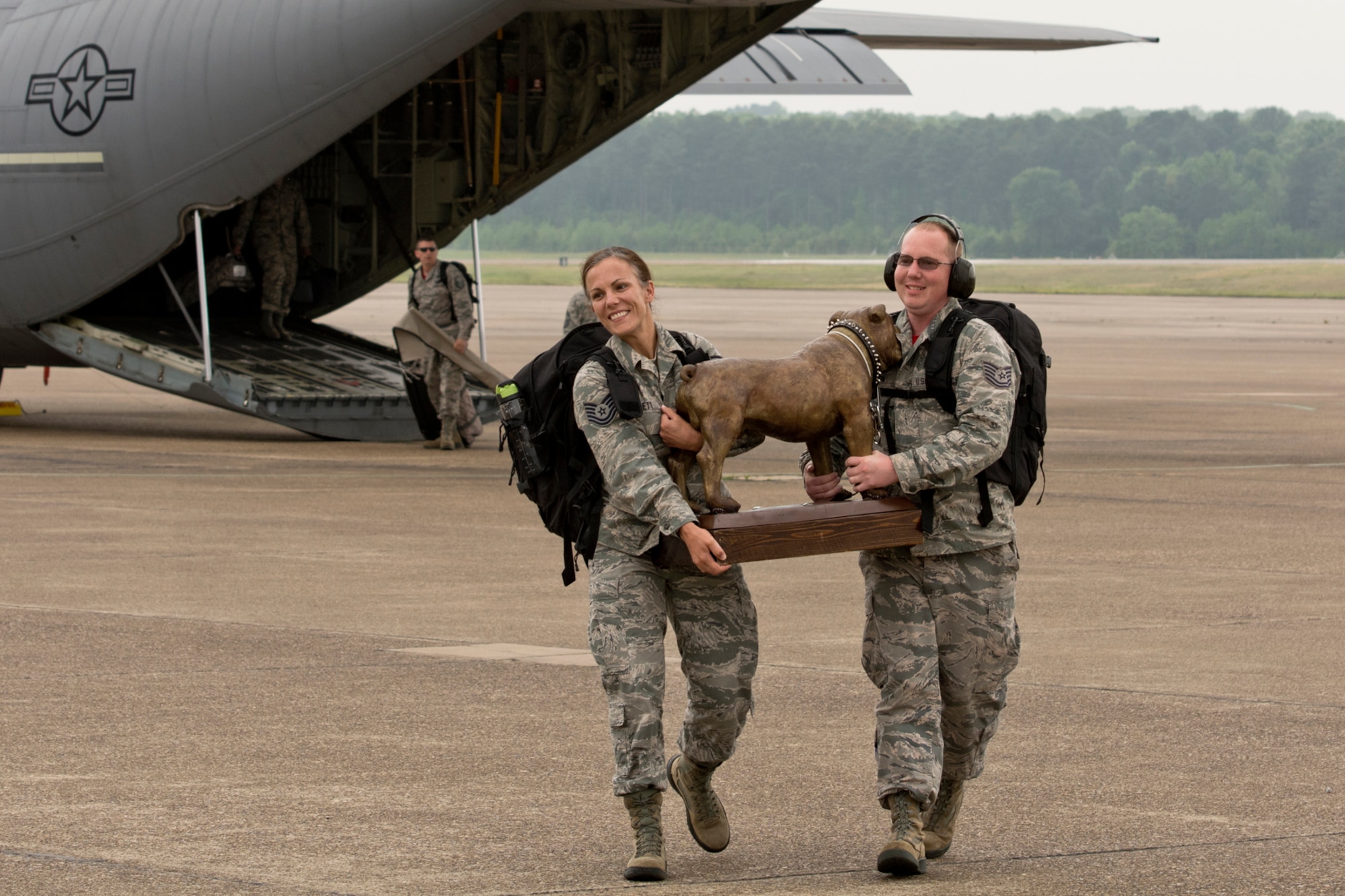 U.S. Air Force Reserve Tech Sgts. Kristen Garrett and Jason Gibson, air transportation specialists assigned to the 96th Aerial Port Squadron, carry the “Top-Dawg” trophy across the ramp upon their arrival April 28, 2017 at Little Rock Air Force Base, Ark. The 96th APS is the first repeat winner since the competition began in 2010. (U.S. Air Force photo by Master Sgt. Jeff Walston/Released)