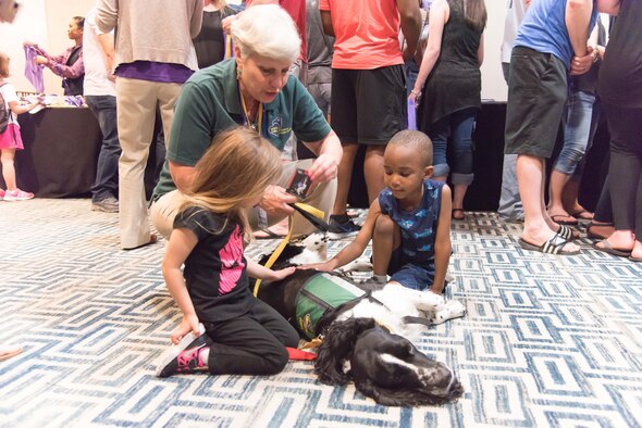 Mary Armstrong, Hope Animal Assisted Crissis Response, Regan Pettis and Te'Maj Sanders pet Hobie during a Yellow Ribbon program event in New Orleans, April 21-23. (U.S. Air Force photo by Staff Sgt. Heather Heiney)