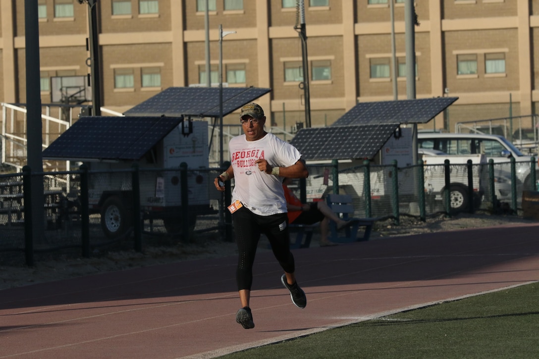 U.S. Army Sgt. Raymond Regan, human intelligence collector, Headquarters and Headquarters Company, 854th Engineer Battalion, runs to the finish line first overall at the Army Reserve 5k Walk or Run, April 22, at Camp Arifjan, Kuwait. The Army Reserve Engagement Cell hosted this annual event as part of a celebratory day geared toward honoring the men and women who serve in the U.S. Army Reserves.