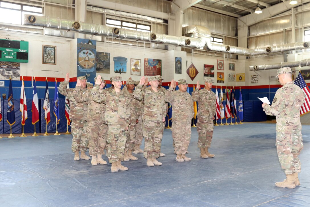 U.S. Army Brig. Gen. Stephen Hager (right), commander of the 335th Signal Command, reads Soldiers the Oath of Enlistment, April 22, at Camp Arifjan, Kuwait. The Army Reserve Engagement Cell hosted this annual event, as part of a celebratory day geared toward honoring the men and women who serve in the U.S. Army Reserves.