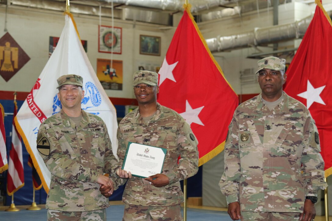 U.S. Army Brig. Gen. Stephen Hager (left), commander of the 335th Signal Command, congratulates Army Spc. Donivan Carter (center), automated logistical specialists, 978th Composite Supply Company, on continuing his commitment to the U.S. Army Reserves, April 22, at Camp Arifjan, Kuwait. The Army Reserve Engagement Cell hosted this annual event, as part of a celebratory day geared toward honoring the men and women who serve in the U.S. Army Reserves.
