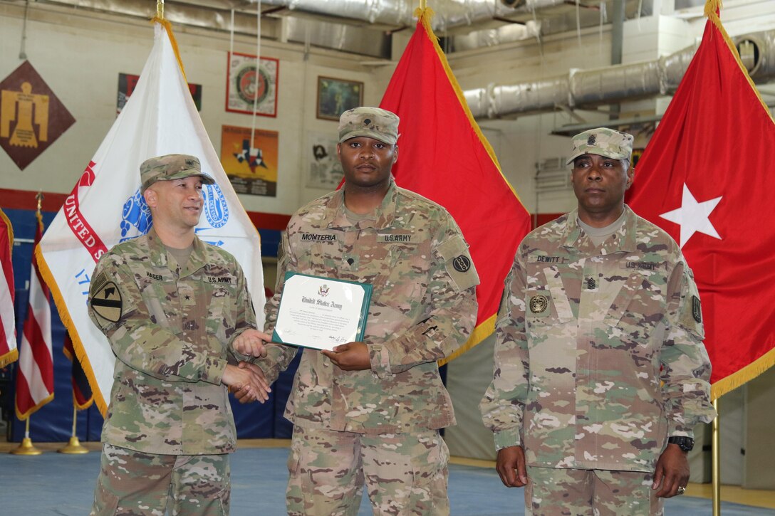 U.S. Army Brig. Gen. Stephen Hager (left), commander, 335th Signal Command, congratulates Army Spc. Deonte Monteria (center), automated logistical specialist, 978th Quartermaster Company, on continuing his commitment to the U.S. Army Reserves, April 22, at Camp Arifjan, Kuwait. The Army Reserve Engagement Cell hosted this annual event, as part of a celebratory day geared toward honoring the men and women who serve in the U.S. Army Reserves.