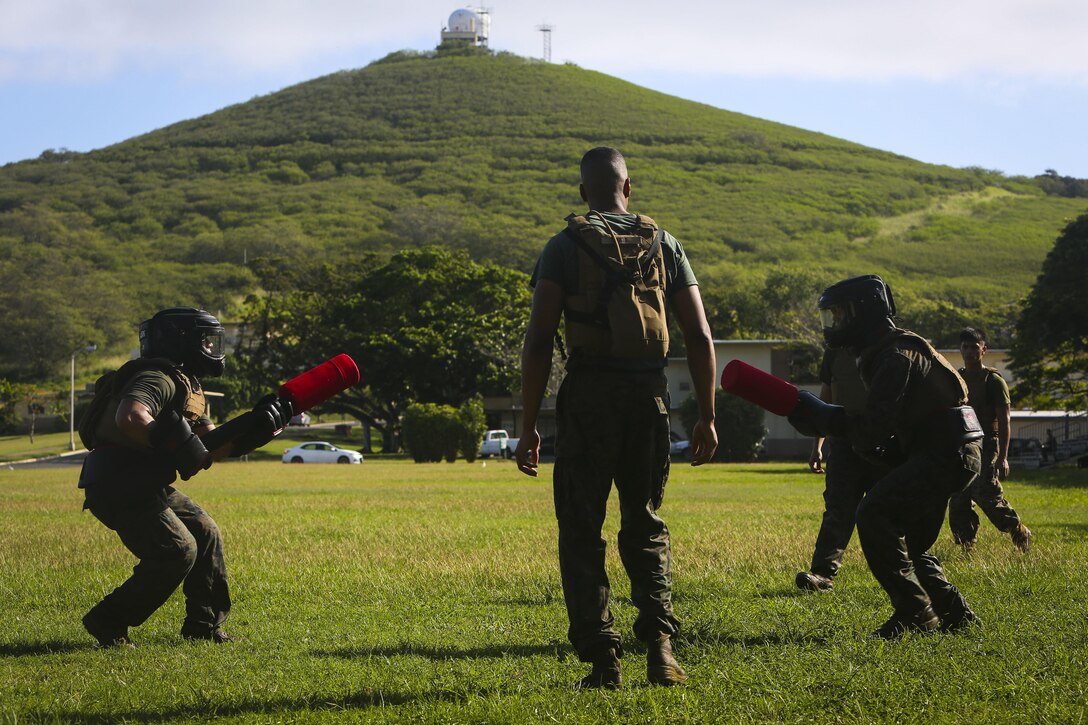 Marine Corps Sgt. Barkim Hall referees a pugil stick fight as part of a martial arts instructor course at Marine Corps Base Hawaii, May 1, 2017. Marine Corps photo by Cpl. Zachary Orr