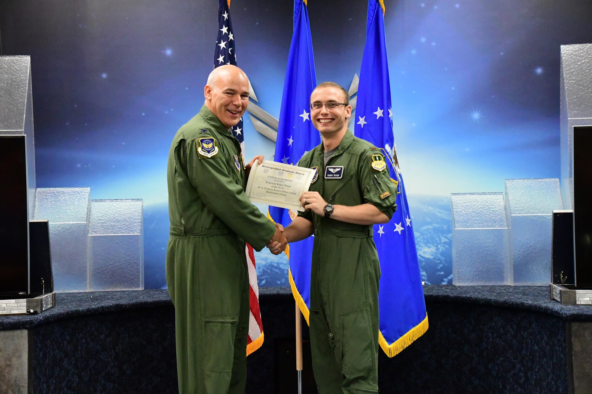 Col. Patrick Matthews, Eighth Air Force vice commander, presents the Weapons Systems Officer Distinguished Graduate Award to 2nd Lt. Robert Irvine during a Formal Training Unit graduation ceremony April 28, 2017, at Barksdale Air Force Base, La. Irvine graduated from the FTU as an Electronic Warfare Officer on the B-52H Stratofortress. (U.S. Air Force photo by Master Sgt. Dachelle Melville/Released)