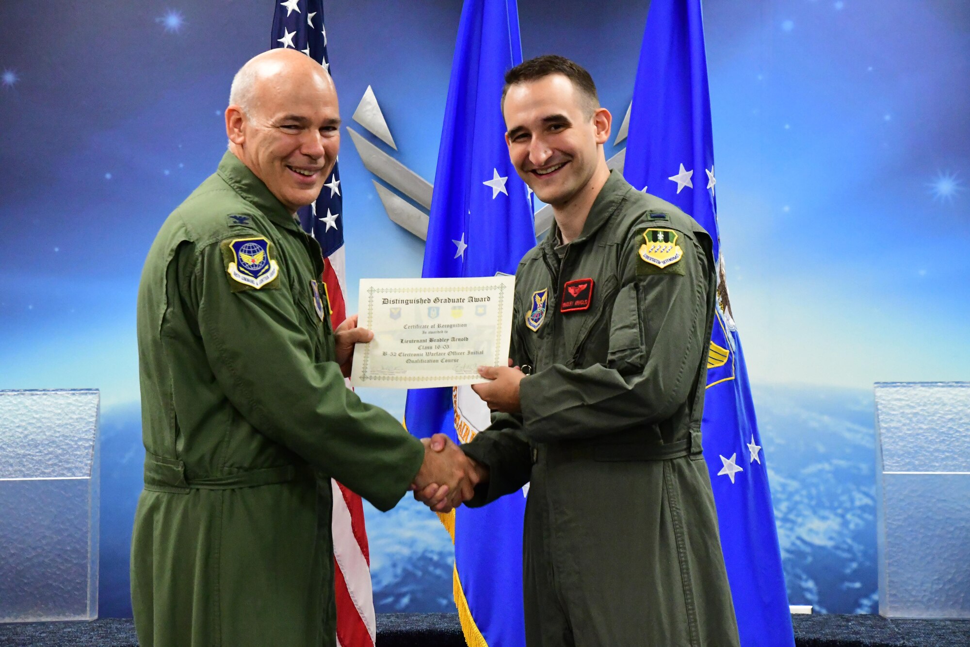 Col. Patrick Matthews, Eighth Air Force vice commander, presents the Electronic Warfare Officer Distinguished Graduate Award to 1st Lt. Bradley Arnold during a Formal Training Unit graduation ceremony April 28, 2017, at Barksdale Air Force Base, La. Arnold graduated from the FTU as an Electronic Warfare Officer on the B-52H Stratofortress. (U.S. Air Force photo by Master Sgt. Dachelle Melville/Released)