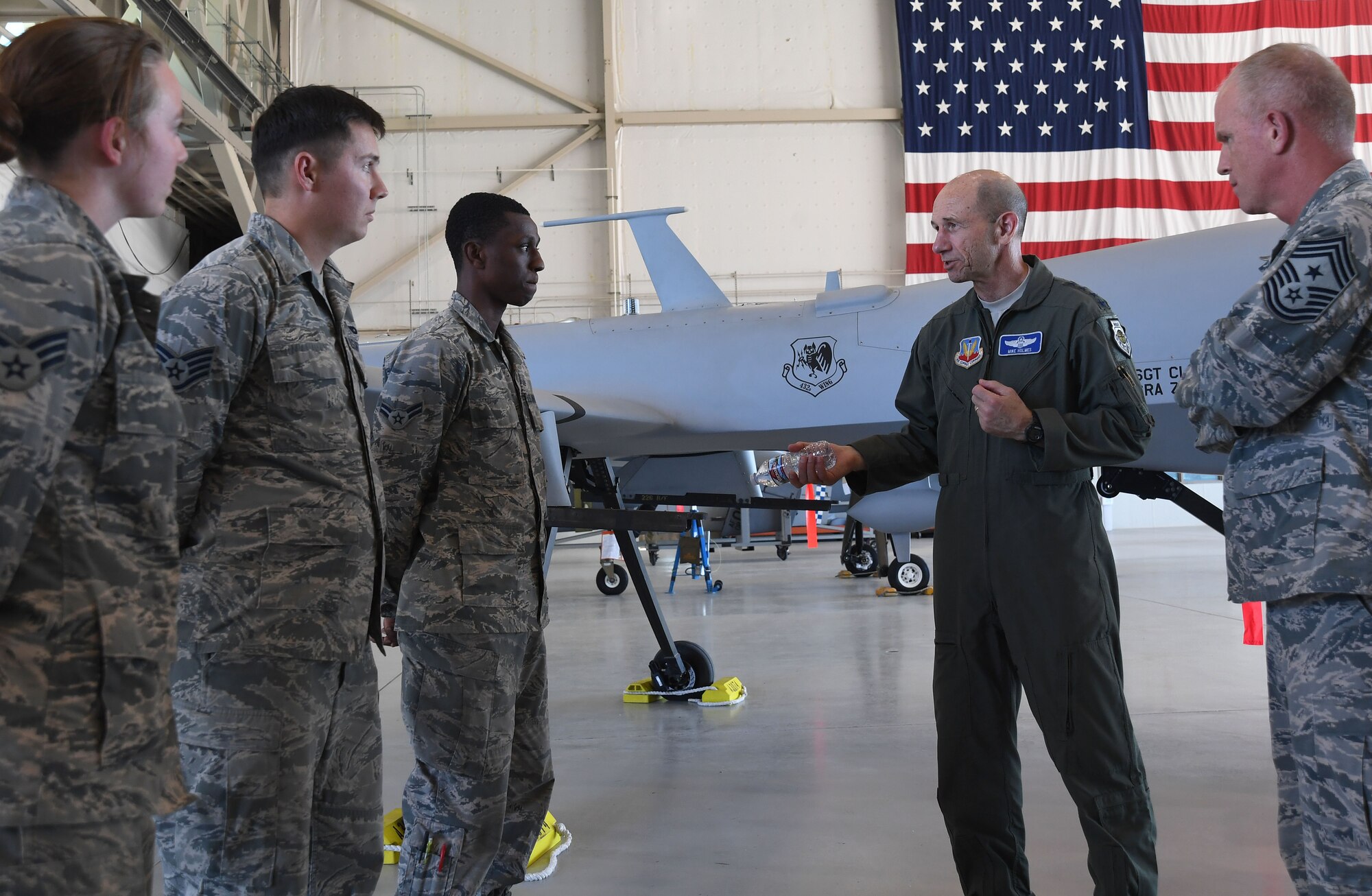 Airmen assigned to the 432nd Maintenance Group speak with Gen. Mike Holmes, commander of Air Combat Command, and ACC Command Chief Master Sgt. Frank Batten, during their first official visit to Creech Air Force Base, Nev., May 1, 2017. The 432nd Maintenance Group is responsible for maintaining both the MQ-1 Predator and the MQ-9 Reaper in support of combat operations anywhere in the world 24 hours a day, seven days a week, 365 days. (U.S. Air Force photo by Airman 1st Class James Thompson)