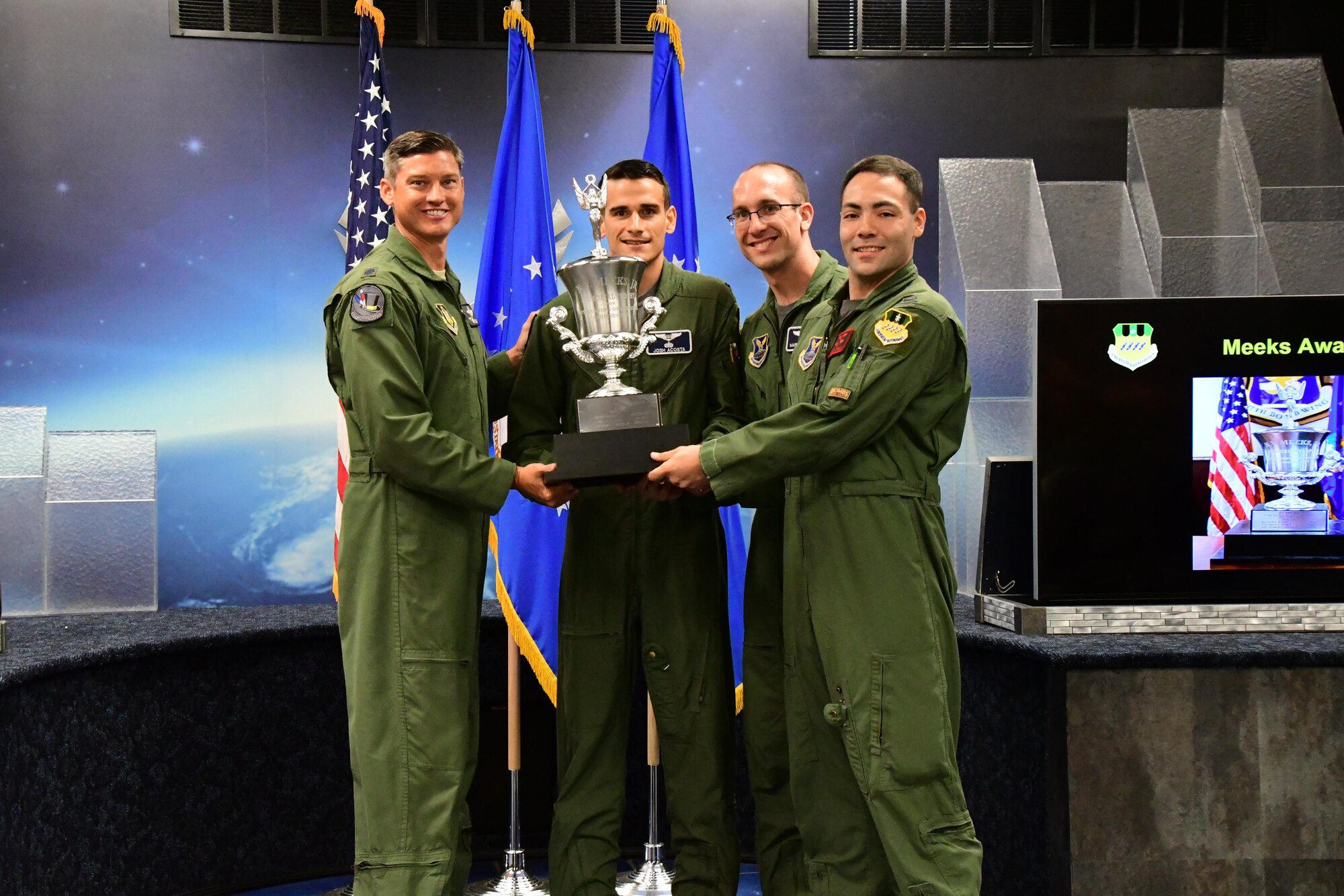 Lt. Col. Brent Weisner, 93rd Bomb Squadron commander, presents the Meeks Outstanding Crew Award to 1st Lt. Joshua Acosta, 2nd Lt. Mark Edwards and 1st Lt. Cody Moran during a Formal Training Unit graduation ceremony April 28, 2017, at Barksdale Air Force Base, La. The award is presented to the student aircrew that performs the best throughout the flight line phase of training. (U.S. Air Force photo by Master Sgt. Dachelle Melville/Released)