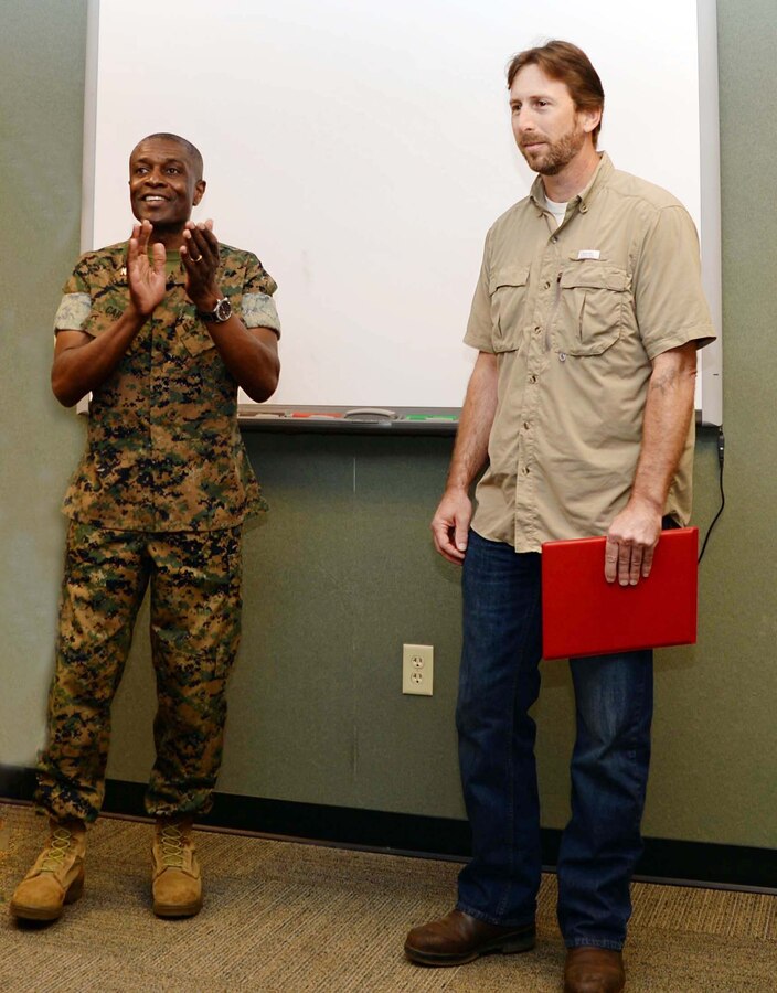 Col. James C. Carroll III (left), commanding officer, Marine Corps Logistics Base Albany, presents the Marine Corps Installations EAST, 2016 Civilian of the Year Award to Brian Cox, work leader, Heating, Ventilation and Air Conditioning, Public Works Branch, MCLB Albany, in a ceremony, here, recently. The commendation was presented on behalf of Brig. Gen. Thomas Weidley, commanding general, MCIEAST, Camp Lejeune, N.C. A number of Cox’s colleagues as well as family members attended the event.