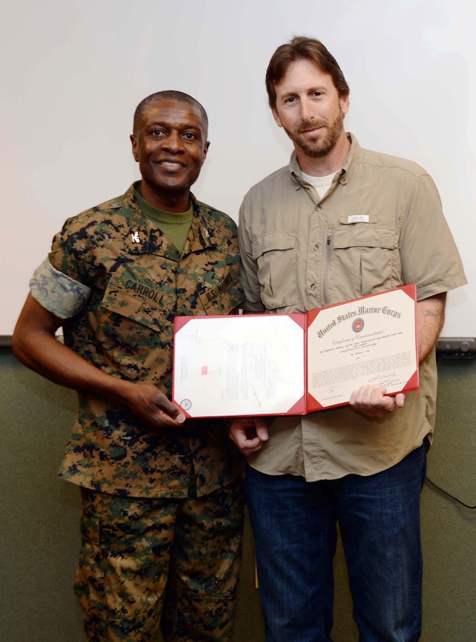 Col. James C. Carroll III (left), commanding officer, Marine Corps Logistics Base Albany, presents the Marine Corps Installations EAST, 2016 Civilian of the Year Award to Brian Cox, work leader, Heating, Ventilation and Air Conditioning, Public Works Branch, MCLB Albany, in a ceremony, here, recently. The commendation was presented on behalf of Brig. Gen. Thomas Weidley, commanding general, MCIEAST, Camp Lejeune, N.C. A number of Cox’s colleagues as well as family members attended the event.