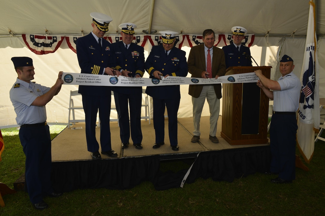 Coast Guard admiral, Michael J. Haycock, Capt. Thomas Remmers, Capt. Scott Keister and Brian D'Isernia cut the ceremonial ribbon during the Offshore Patrol Cutter stand-up ceremony in Panama City, Florida, May 3, 2017. U.S. Coast Guard photo by Petty Officer 1st Class Mark Barney.