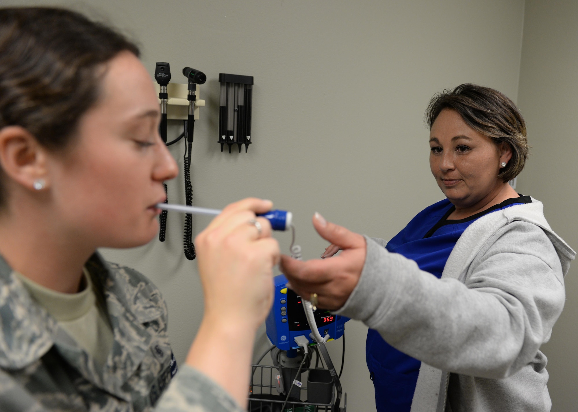 Jennifer Jones, 97th MDOS licensed practicing nurse, takes the temperature of a patient, May 3, 2017, at Altus Air Force Base, Oklahoma. Nurses and technicians handle a variety of care for patients and are constantly trained to provide the best support. (U.S. Air Force Photo by Airman 1st Class Jackson N. Haddon/Released).