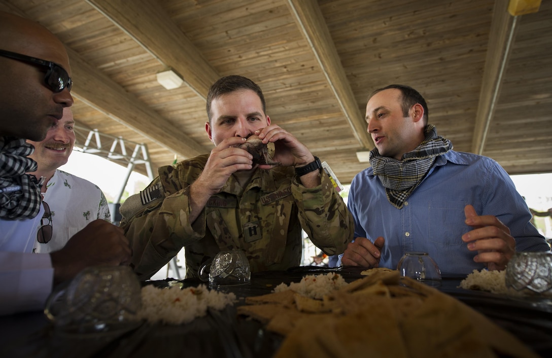 Capt. Ian Hocking, a combat aviation advisor student with the 6th Special Operations Squadron, sucks the eyes out of a fish head during Operation Raven Claw at Duke Field, Fla., April 26, 2017. Students joined their partners in a meal that is considered a luxury in “Palmetto Land” culture to strengthen relationships. (U.S. Air Force photo by Airman 1st Class Joseph Pick)