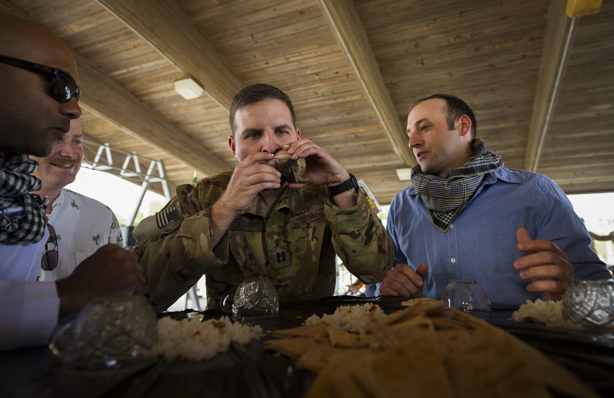 Capt. Ian Hocking, a combat aviation advisor student with the 6th Special Operations Squadron, sucks the eyes out of a fish head during Operation Raven Claw at Duke Field, Fla., April 26, 2017. Students joined their partners in a meal that is considered a luxury in “Palmetto Land” culture to strengthen relationships. (U.S. Air Force photo by Airman 1st Class Joseph Pick)