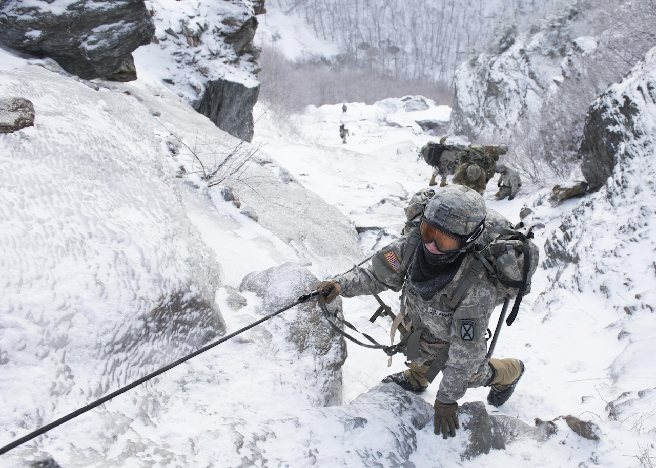 Army Pfc. Olivia French, a medic with the 7th Engineer Battalion, 10th Mountain Division, climbs the mountain at Smugglers' Notch in Jeffersonville, Vt., Feb. 18, 2016. The Mountain Walk is a culminating event for basic and advanced mountain warfare students to use the skills taught at the Army Mountain Warfare School at the Camp Ethan Allen training site. Air Force photo by Tech. Sgt. Nathan Rivard