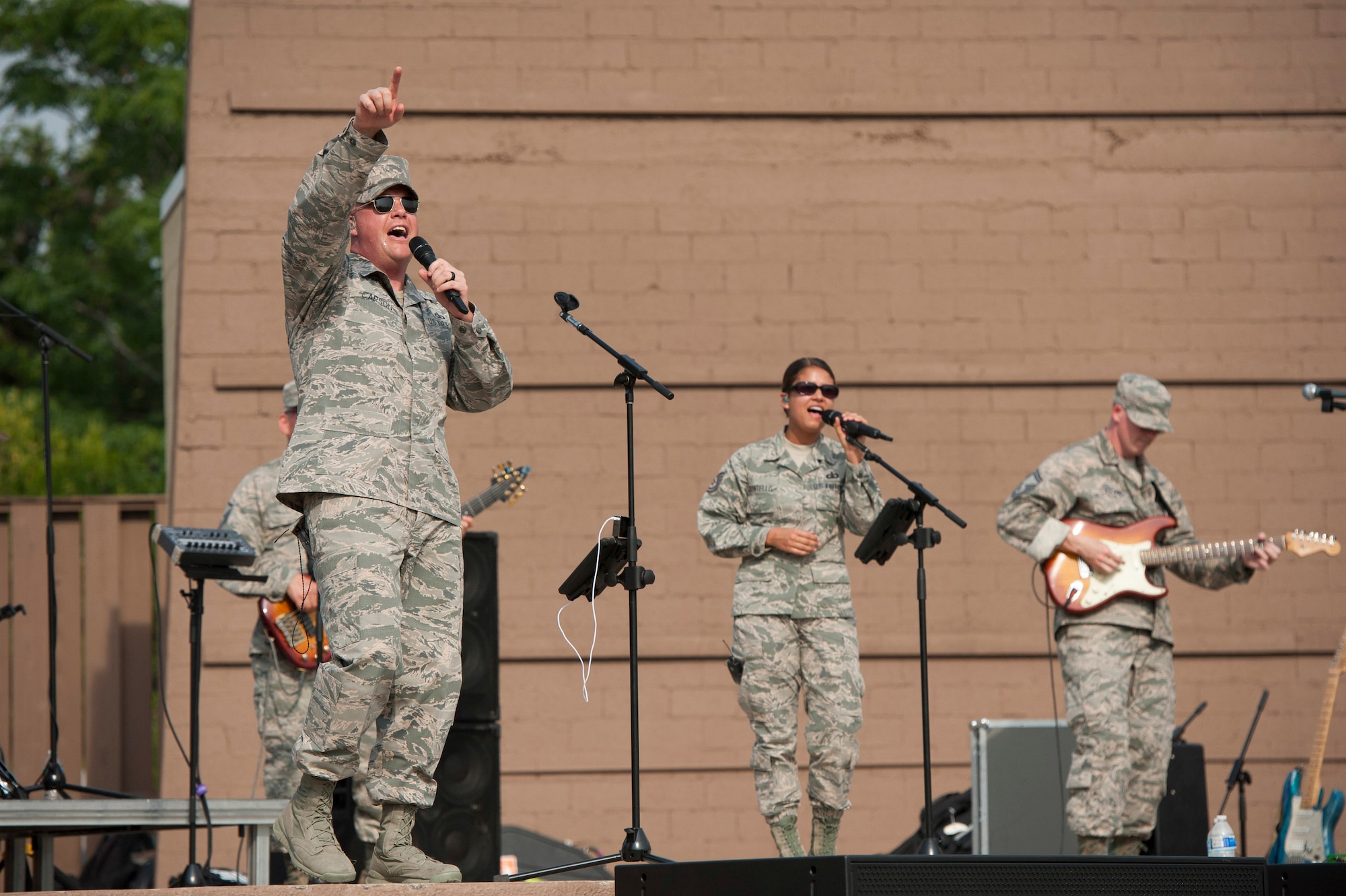 Senior Master Sgt. Ryan L. Carson, Superintendent and a vocalist, points into the crowd during a performance at the Air Force Basic Military Training Cadre's annual BBQ. The United States Air Force Band’s premier rock band, Max Impact and their debut of a song and video written especially for the 37th Training Wing Basic Military Training Cadre and support staffs. This was written as a recognition and thank you for their service and mission to, “Transform civilians into motivated, disciplined warrior Airmen with the foundation to serve in the world’s greatest Air Force.” The debut took place at Joint Base San Antonio – Lackland, Saturday April 29, 2017. (U.S. Air Force photo by Staff Sgt. Daniel Owen)