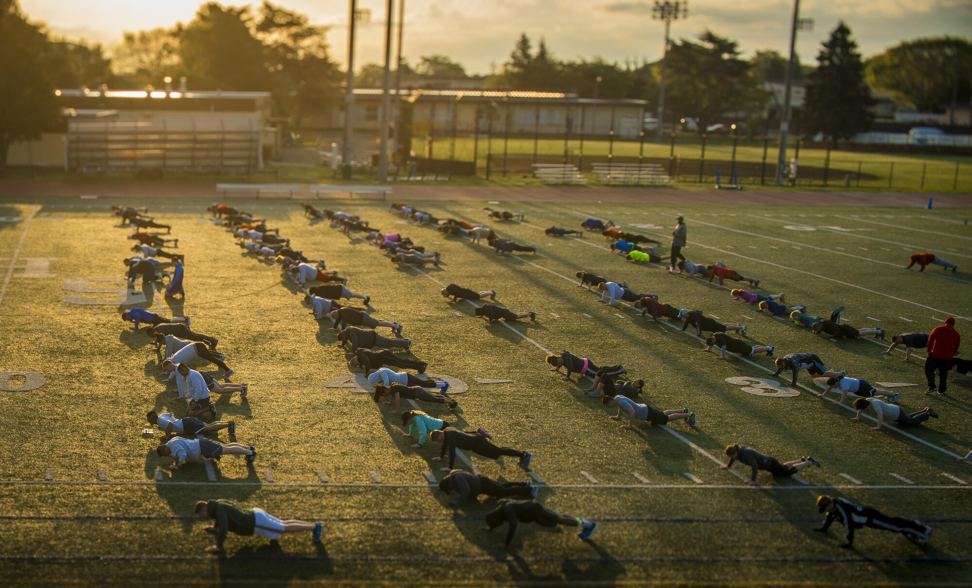 Participants of the Warrior Run fitness program perform push-ups April 28, 2017, at Yokota Air Base, Japan. The Warrior Run currently has about 115 participants during the morning session and about 30 participants during the afternoon session. (U.S. Air Force photo by Airman 1st Class Donald Hudson)