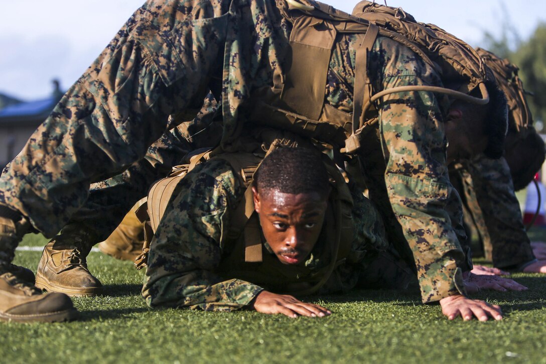 Marine Corps Cpl. Israel Prater crawls under his squad at the beginning of the “build a house” exercise for a martial arts course at Marine Corps Base Hawaii, May 1, 2017. The three-week long course puts students through various training that includes physical training and evaluations on properly teaching techniques. Prater is an air support operations operator assigned to the 11th Marine Expeditionary Unit. Marine Corps photo by Cpl. Zachary Orr