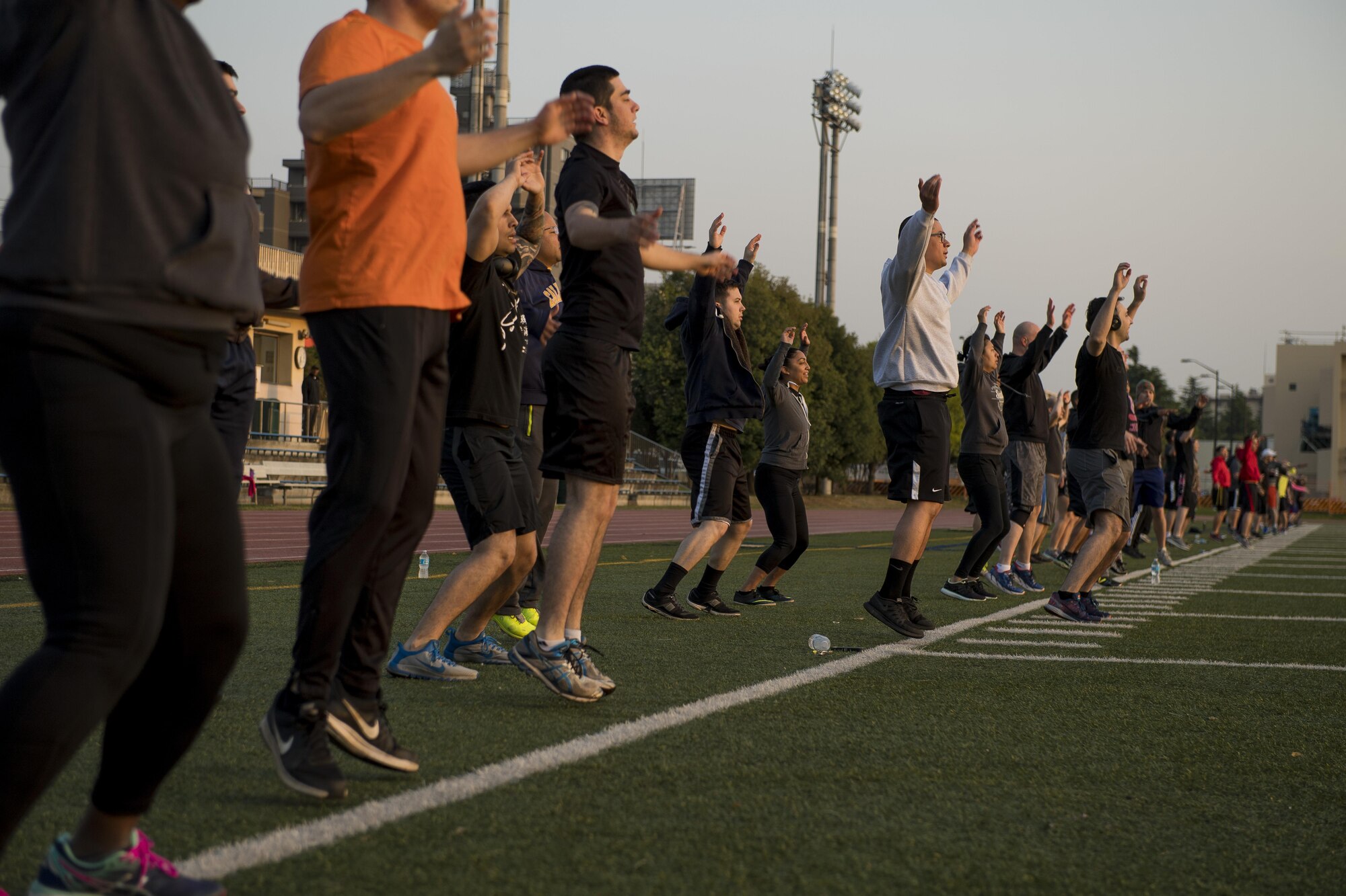 Participants in the Warrior Run fitness program perform jumping-jacks May 1, 2017, at Yokota Air Base, Japan. The Warrior Run currently has about 115 participants during the morning session and about 30 participants during the afternoon session. (U.S. Air Force photo by Airman 1st Class Donald Hudson)