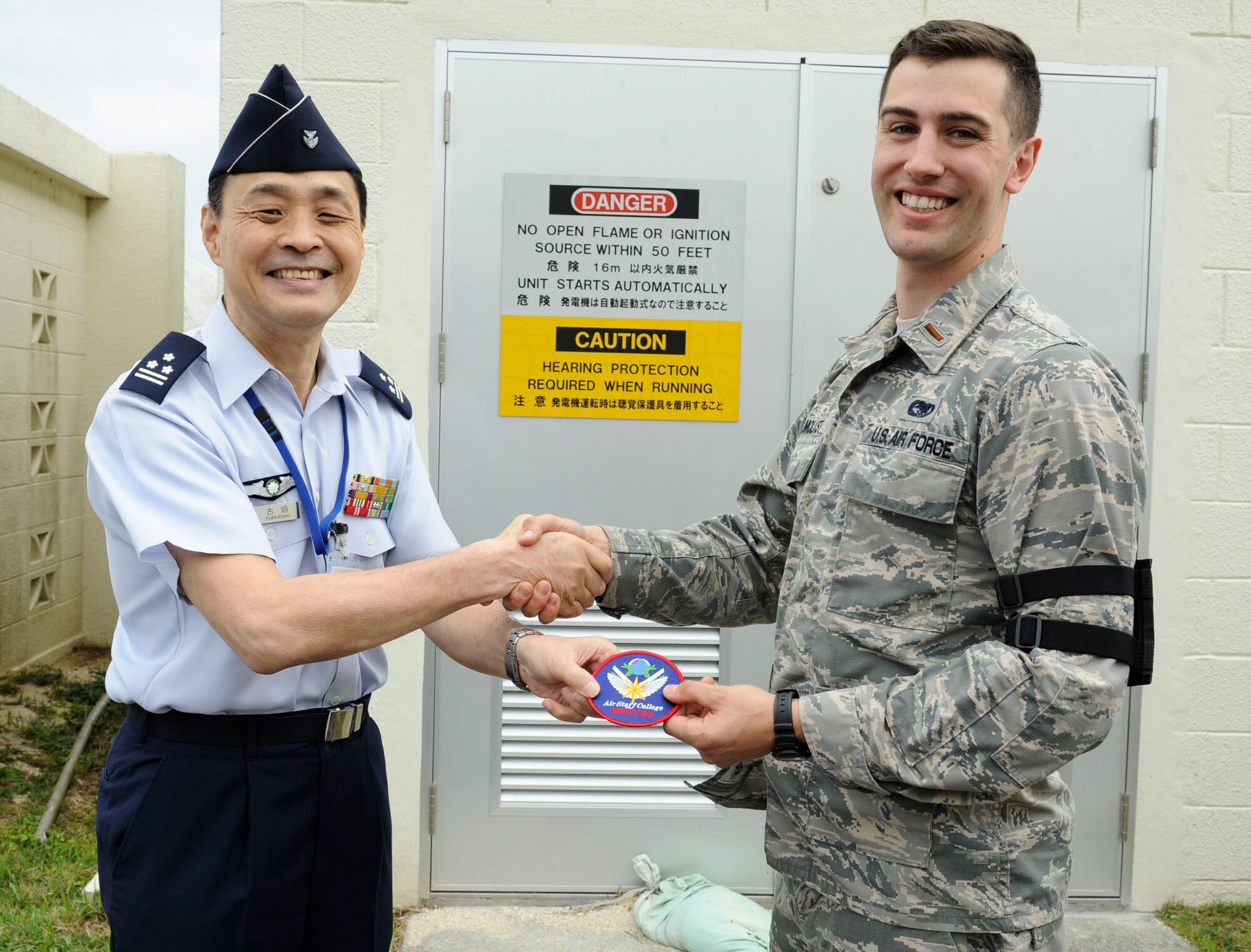 Japan Air Self-Defense Force Col. Riichi Furugaki, JASDF Air Staff College director of education department, presents a JASDF Air Staff College patch to U.S. Air Force 2nd Lt. William Holmquist, 18th Logistics Readiness Squadron fuels operations officer, April 27, 2017, at Kadena Air Base, Japan. The 18th LRS petroleum, oils and lubricants flight maintains relationships with fellow JASDF members by hosting frequent tours of their facilities. (U.S. Air Force photo by Senior Airman Lynette M. Rolen)