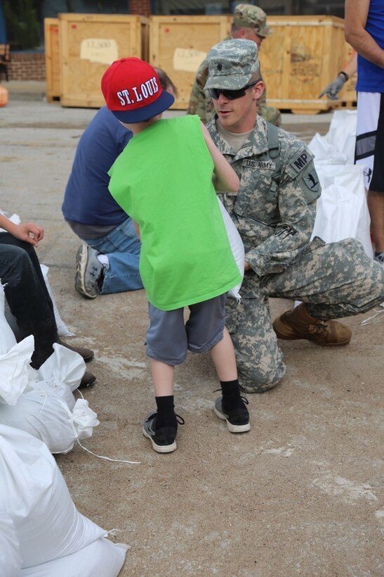 A child helps a Missouri National Guardsmen fill sandbags in Eureka, Mo., May 2, 2017. The guardsmen are assigned to the 835th Military Police Battalion and 1035th Maintenance Company. Army National Guard photo by Pvt 1st Class Garrett Bradley