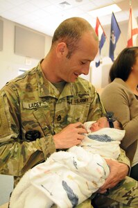 Sgt. 1st Class Jeremy Lacey, U.S. Army Reserve career counselor, holds his daughter Anastasia May 3 during Operation Homefront’s Star-Spangled Babies event at Joint Base McGuire-Dix-Lakehurst, New Jersey. Roughly 70 new and expecting military mothers received a free crib from Delta Children as well as other gifts.