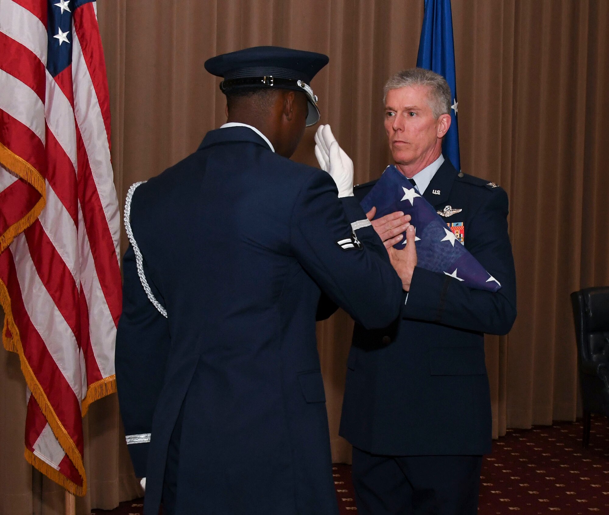 A Barksdale Honor Guardsman presents Col. James L. Morriss III, the 307th Bomb Wing vice commander, with a folded U.S. flag at Barksdale Air Force Base, La., April 29, 2017.  Morriss retired from the Air Force after serving 31 years in the military. (U.S. Air Force photo by Staff Sgt. Callie Ware/Released)